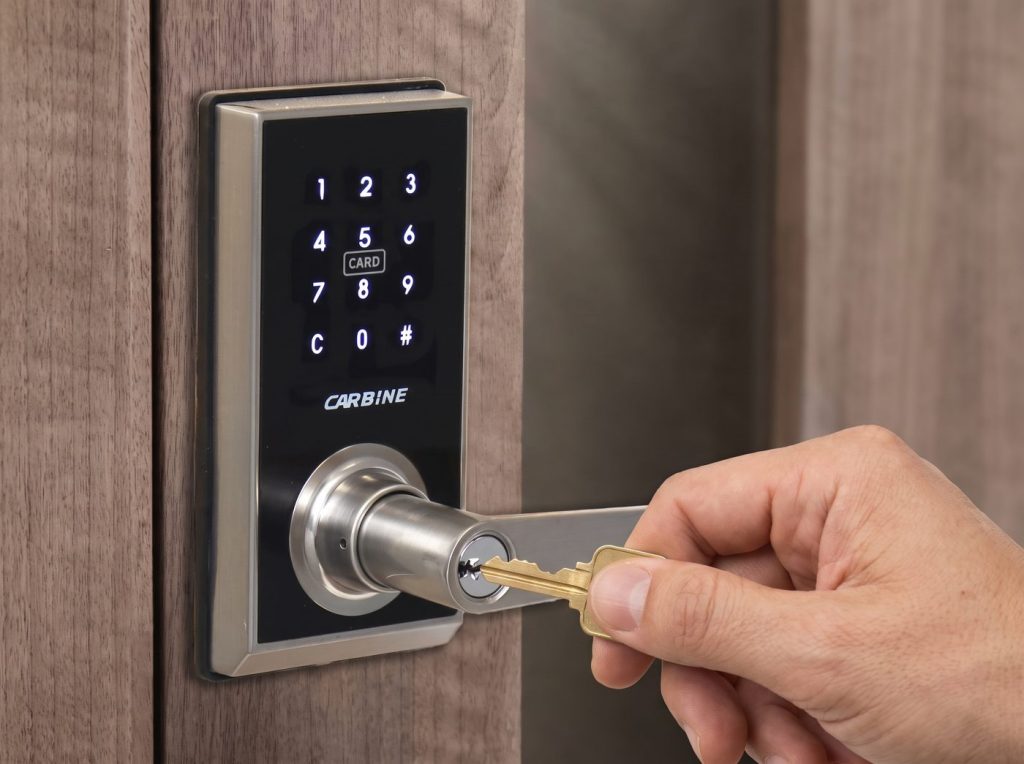 A hand putting a house key into the key cylinder of a digital door lock
