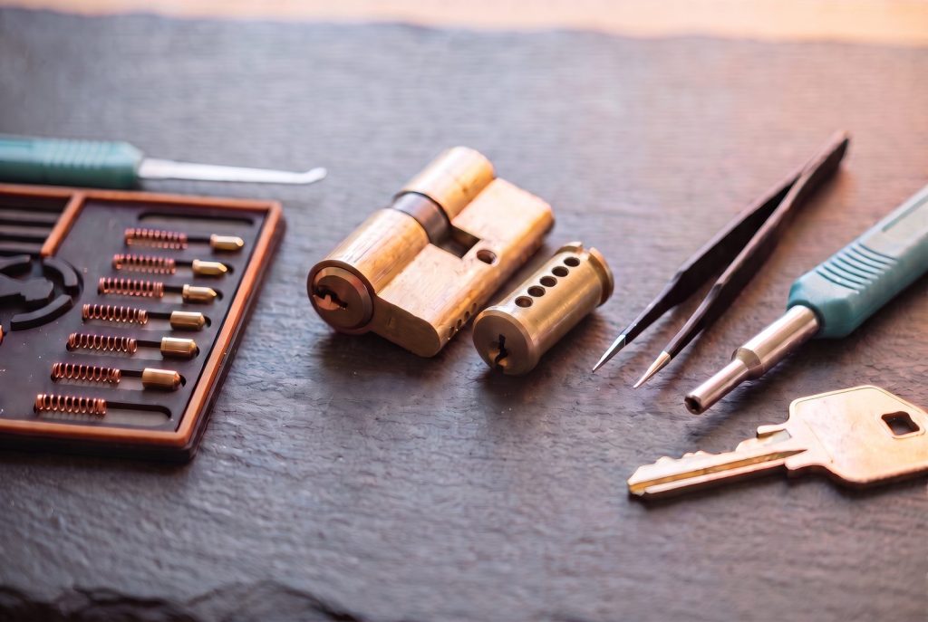Lock cylinder taken apart on a workbench with the pins, springs and a newly cut key